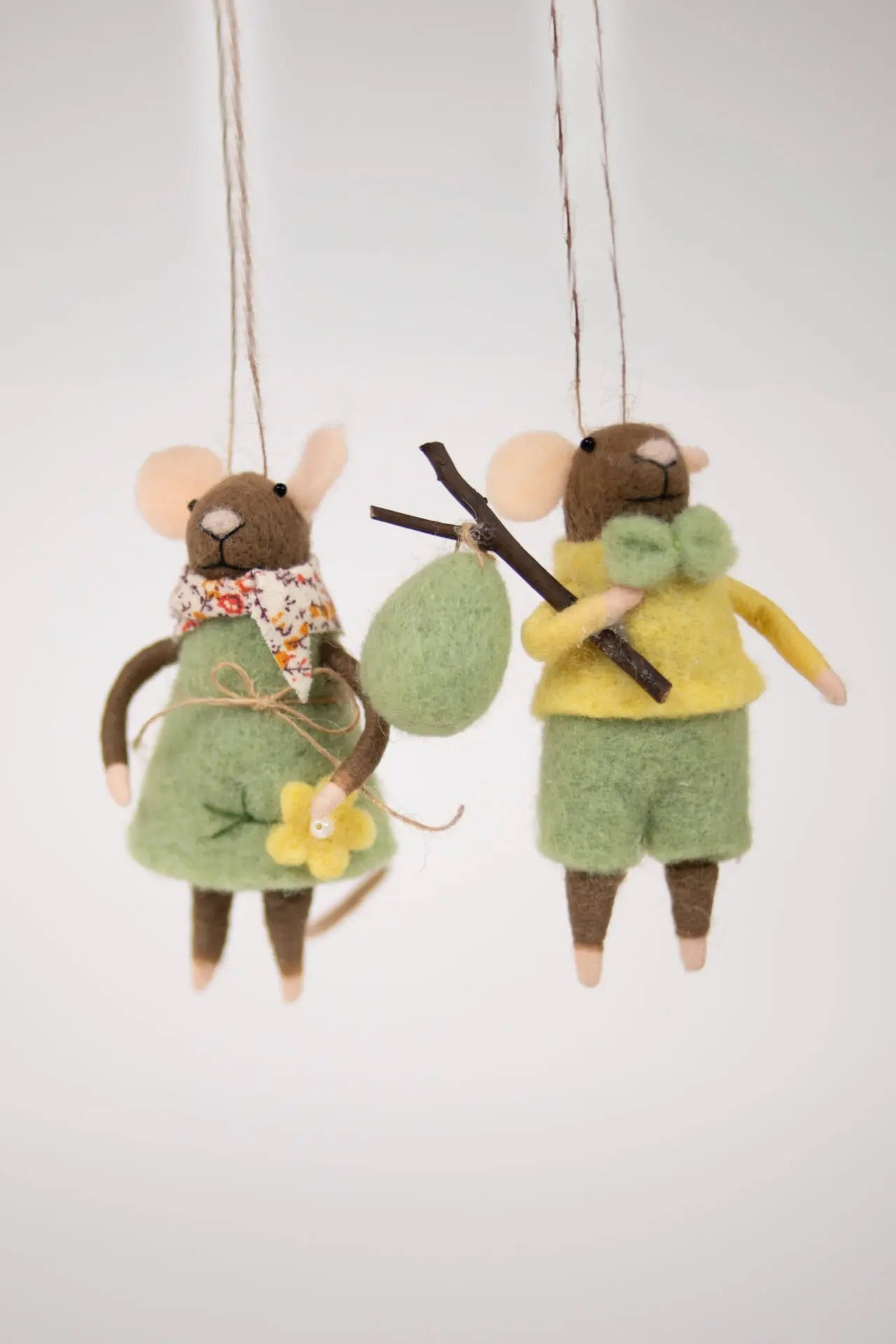 Brun mus med grønn bukse og påskeegg