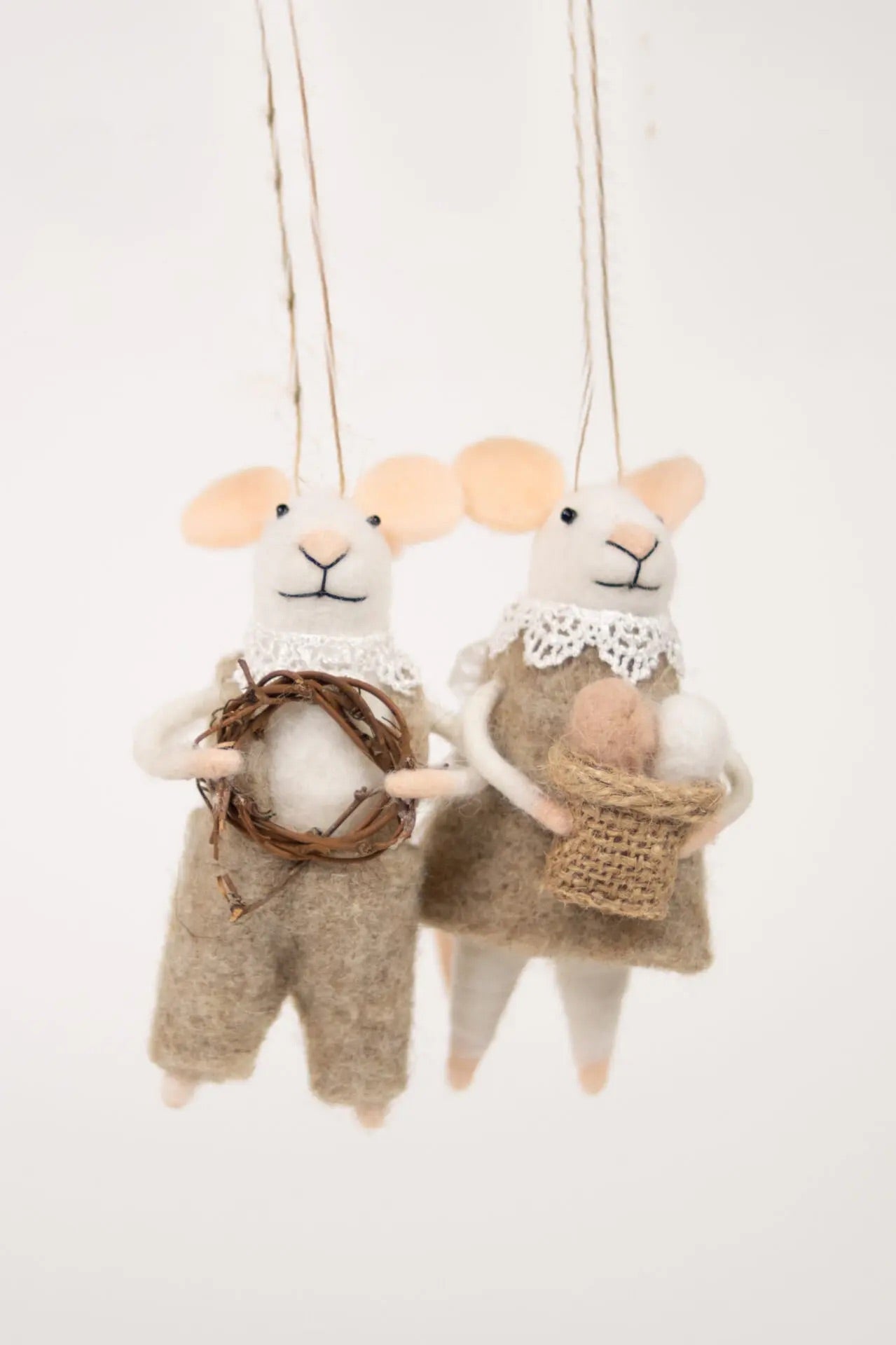 Hvit mus med snekkerbukse og krans