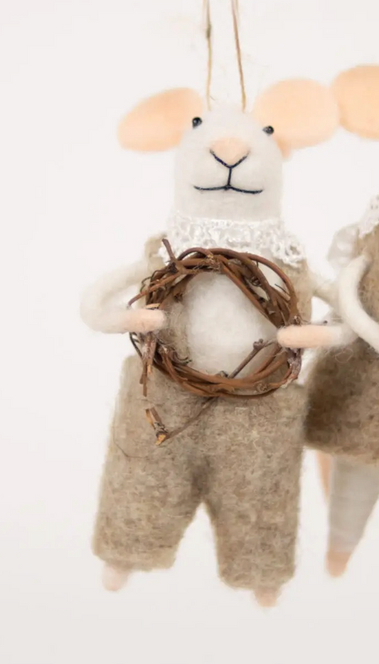 Hvit mus med snekkerbukse og krans