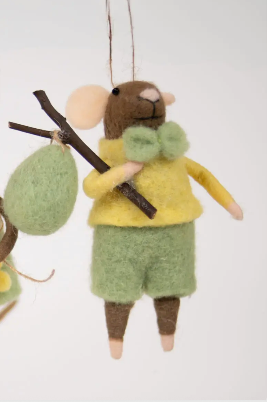 Brun mus med grønn bukse og påskeegg